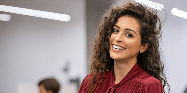 600×400 office worker businesswoman standing in creative office and looking at camera while smiling.