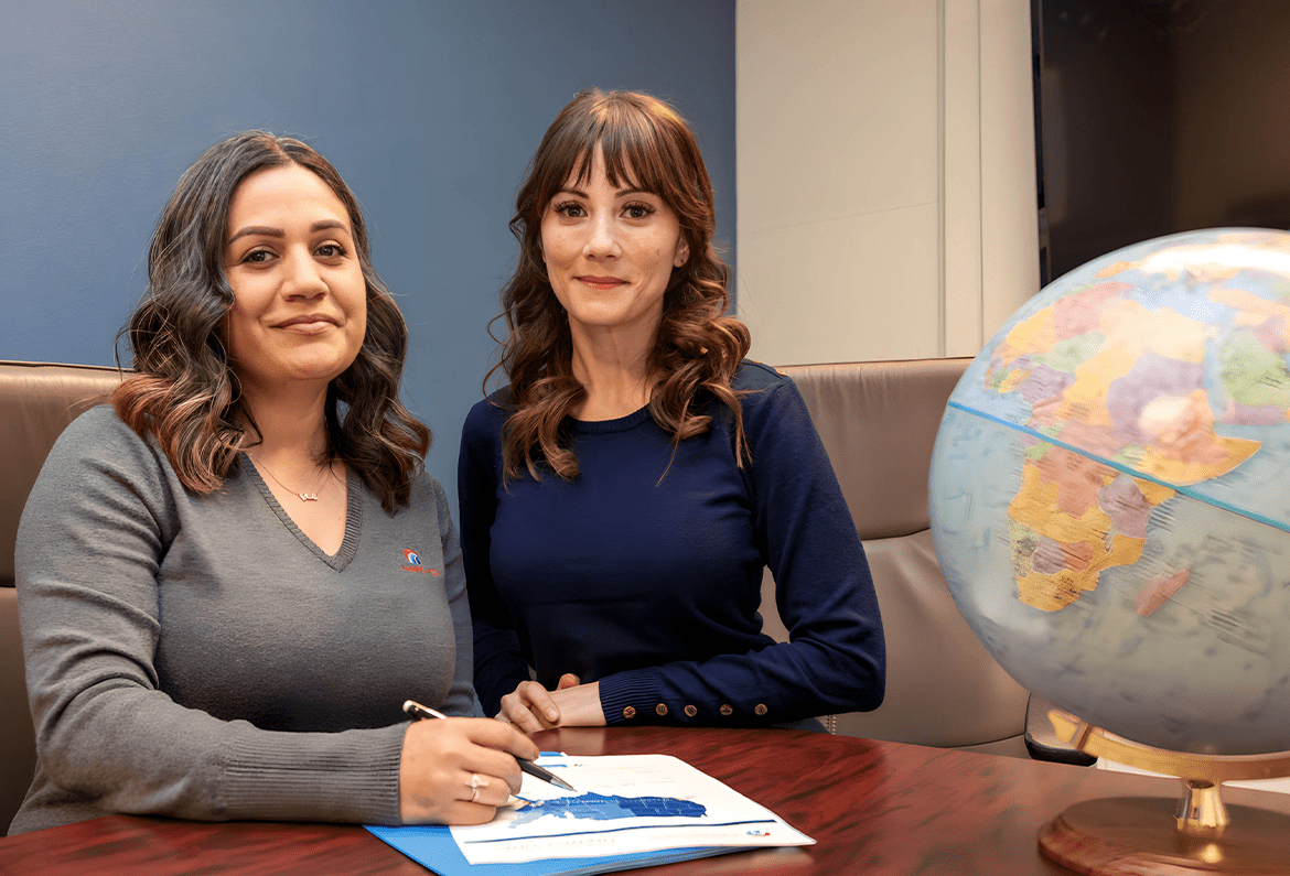1170×795 our difference two managers in a conference room with globe and paperwork